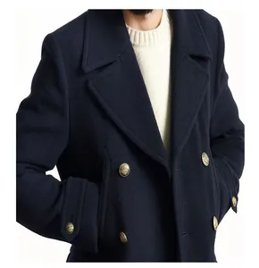 Dettaglio di un cappotto in lana blu navy con bottoni dorati stemmati in stile marinaresco.