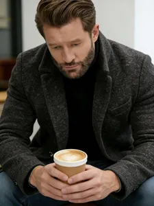 Detailed shot of a man wearing a grey mid-length wool overcoat in a stylish winter look.