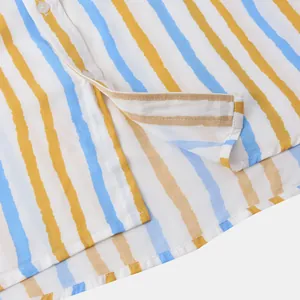 Gros plan sur l'ourlet et les coutures de cette chemise de plage à rayures jaunes et bleues