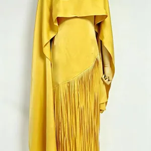 Detail view of a vibrant yellow acetate dress with elegant long fringe tassels and shrug