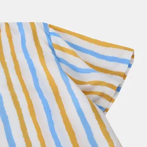 Détail rapproché du motif rayé bleu et jaune sur la manche d'une chemise pour homme