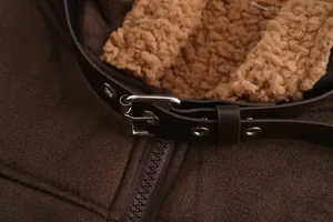 Dettaglio ravvicinato di una giacca in finta pelle scamosciata marrone con fodera sherpa.