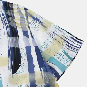 Gros plan sur l'imprimé abstrait bleu et jaune d'une chemise de plage à manches courtes