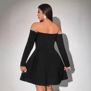Detailed back view of black off-the-shoulder mini dress with pearl embellished neckline