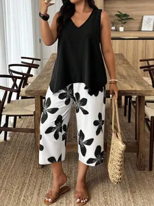 Completo due pezzi con top nero senza maniche e pantaloni ampi a fiori dal taglio corto.
