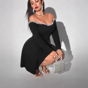 Detail of black off-the-shoulder dress with pearl trim and waist-slimming fit