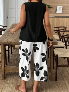 Elegante completo da donna in due pezzi con top nero senza maniche e pantaloni larghi a fiori