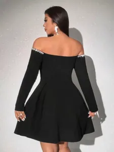 Elegant black off-the-shoulder long sleeve mini dress featuring pearl embellished neckline
