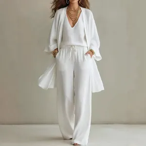 Ganzkörperansicht des eleganten weißen 3-Teilers aus Leinen mit Strickjacke und Hose