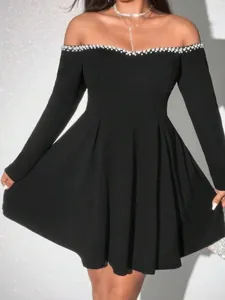 Elegant off-the-shoulder black mini dress with pearl embellishments and long sleeves