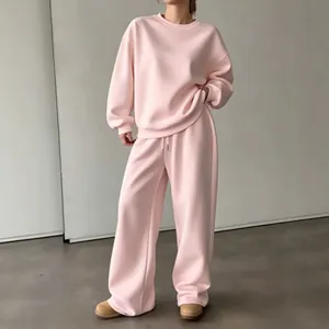Dettaglio della tuta rosa oversize con girocollo morbido e pantaloni a gamba larga.