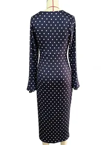 Long-sleeved navy blue polka dot dress with lace cuffs shown on a mannequin, back view.