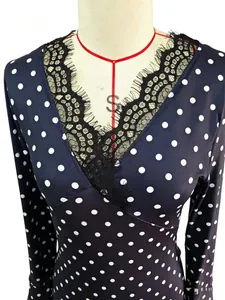 Detailed view of women's V-neck polka dot dress with exquisite black lace trim.