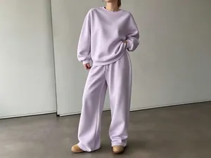 Dettaglio di felpa lavanda oversize e set di pantaloni a gamba larga sul modello.