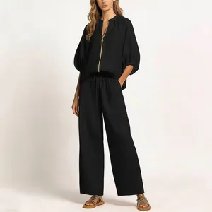 Full-length view of a black two-piece set featuring a zip blouse and wide-leg pants