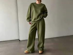 Dettaglio della felpa oversize verde oliva e dei pantaloni larghi coordinati