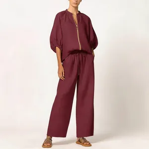 Detail view of women's loose two-piece wine red set with wide-leg pants and zip-up top