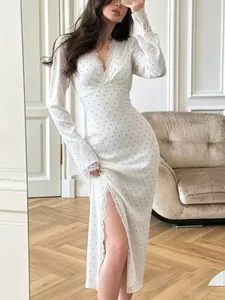 Detail view of white polka dot dress with delicate lace trim and sexy side slit