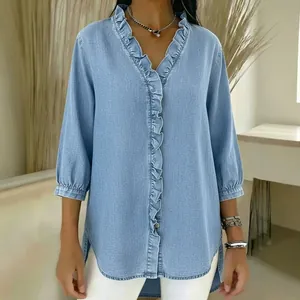 Detailed view of women's casual light blue faux denim blouse with ruffled V-neckline
