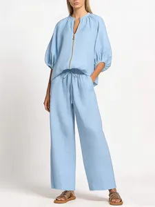 Elegant light blue two-piece set featuring a zipper round neck top and wide-leg trousers.