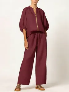 Elegant burgundy two-piece set featuring zip-up puff sleeve top and wide-leg pants