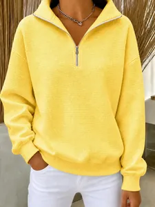 Gros plan du sweat-shirt gaufré jaune avec col demi-zippé et poignets côtelés