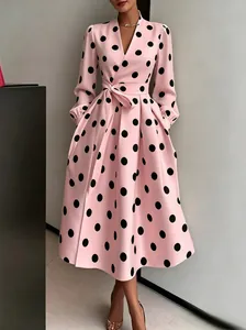 Detail view of a pink retro Audrey Hepburn style dress with bold black polka dots.