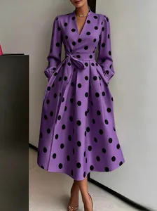 Detailed shot of the elegant vintage purple polka dot midi dress showing waist belt fit.