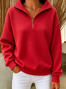 Détail d'un sweat-shirt rouge à quart de zip, texture en maille gaufrée et coupe décontractée