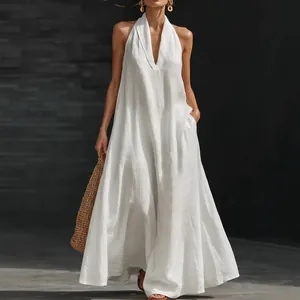 Detailed view of white sleeveless linen maxi dress with deep V-neck and halter style