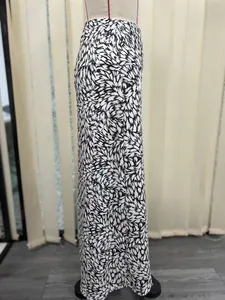 Detail of a black and white abstract print long fishtail skirt with elastic waist.