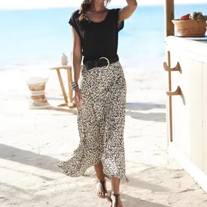 Close-up of a stylish woman wearing a patterned maxi skirt in a sunny beach resort