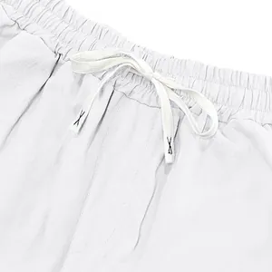 Detailed close-up view of the elastic waistband and white drawstring on linen beach pants