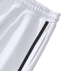 Détail d'un pantalon de sport blanc pour homme avec bande latérale noire et taille.