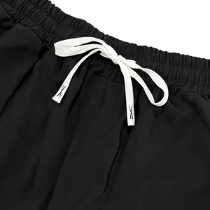 Close-up of the elastic waistband and white drawstring on black linen casual pants.