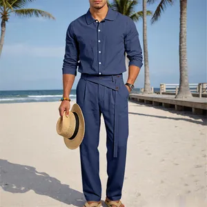 Vue en pied d'un homme portant un ensemble chemise et pantalon en lin bleu marine sur la plage