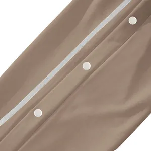 Détail macro des boutons-pression blancs sur le pantalon de sport marron