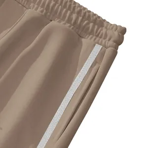 Vue détaillée d'un pantalon de sport pour homme avec taille élastique et rayure blanche.