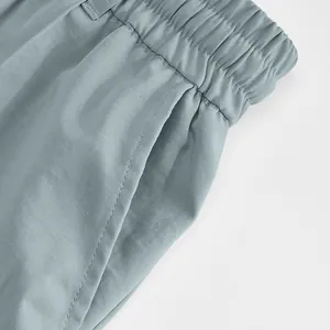 Détail en gros plan de la taille élastique et de la poche latérale d'un pantalon bleu pour homme
