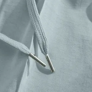 Détail d'un pantalon de costume pour homme montrant le tissu gris et le cordon