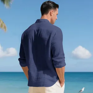 Vista posteriore di una camicia di lino blu da uomo su uno sfondo di spiaggia tropicale calda