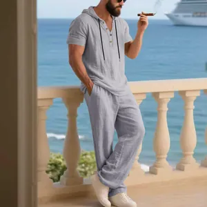 Completo casual da uomo in lino grigio chiaro con felpa a maniche corte e pantaloni sul balcone.
