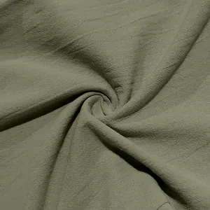 Close-up of olive green breathable linen fabric texture for casual men's beach pants