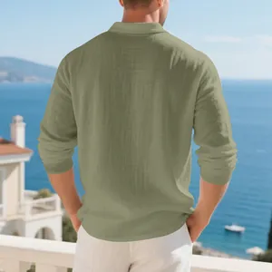 Back view of men's loose sage green cotton linen long-sleeved polo shirt in coastal setting