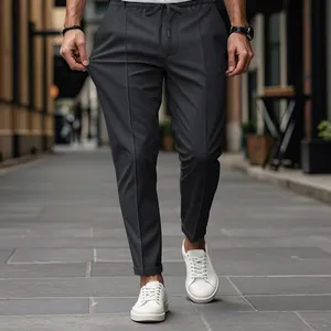 Vue détaillée d'un pantalon de costume noir ajusté pour homme dans un cadre urbain