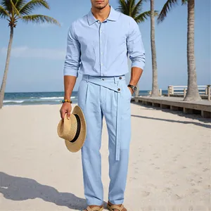 Costume en lin bleu clair pour homme, porté dans un cadre de plage avec un chapeau.