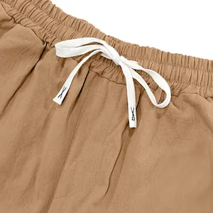 Close-up of men's loose linen pants waistband with white drawstring and elastic band
