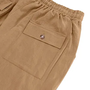 Close-up detail of cargo pocket and elastic waistband on brown men's linen beach trousers