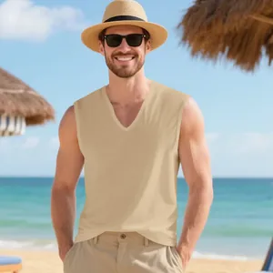 Smiling man wearing a khaki V-neck muscle tank top and straw hat in a tropical beach setting