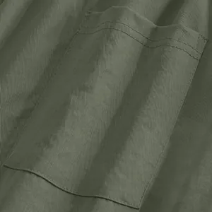 Détail macro d'une poche plaquée olive sur un pantalon de costume droit pour homme.